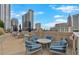 Rooftop terrace with chairs, tables, and city views during the day on a patio at 860 Peachtree Ne St # 2815, Atlanta, GA 30308