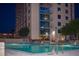 Outdoor pool with lounge chairs with a building view at dusk and interior lights at 860 Peachtree Ne St # 2815, Atlanta, GA 30308