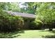 A brick house with green shutters and surrounded by mature trees and lush greenery at 5170 Chamblee Dunwoody Rd, Atlanta, GA 30338