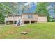 View of backyard with deck, stairs, green grass, and partially wooded area at 5326 Highway 5, Douglasville, GA 30135