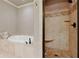 Luxurious bathroom with a soaking tub, tiled shower with a built-in bench and multiple shower heads at 265 Trecastle Sq, Canton, GA 30114