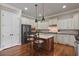 Spacious kitchen featuring white cabinets, black appliances, large center island, and hardwood floors at 265 Trecastle Sq, Canton, GA 30114