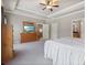 Large main bedroom with carpet flooring, tray ceiling, white trim, TV, and view to the ensuite bathroom at 265 Trecastle Sq, Canton, GA 30114