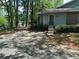 View of a blue and brick home with mature trees and ample parking at 4828 Westridge Dr, Norcross, GA 30093