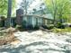 Charming two-story home with a brick chimney and a well-maintained front yard surrounded by lush trees at 4828 Westridge Dr, Norcross, GA 30093
