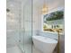 Modern bathroom with a glass-enclosed shower, soaking tub, and stylish gold fixtures and lighting at 551 Lake Dr, Atlanta, GA 30354