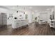 Modern, white kitchen featuring a large island with seating and stainless steel appliances and wood flooring at 551 Lake Dr, Atlanta, GA 30354
