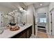Elegant bathroom features a double vanity, quartz countertop, and a door leading to the bedroom at 5650 Bergeson Ways, Cumming, GA 30028