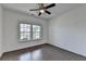 Bright bedroom featuring a ceiling fan, hardwood floors, and double windows at 5650 Bergeson Ways, Cumming, GA 30028