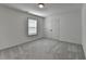 A bedroom featuring neutral carpet, a double door closet, and natural light from the window at 5650 Bergeson Ways, Cumming, GA 30028
