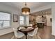 Bright dining area with a round table, stylish chairs, a modern light fixture, with kitchen view at 5650 Bergeson Ways, Cumming, GA 30028