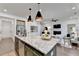 An open kitchen boasts an island with a granite countertop and stylish pendant lighting at 5650 Bergeson Ways, Cumming, GA 30028