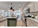 An open kitchen shows a large island with seating, granite countertops, and stainless steel appliances at 5650 Bergeson Ways, Cumming, GA 30028