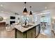 An open kitchen boasts an island with a granite countertop and stylish pendant lighting at 5650 Bergeson Ways, Cumming, GA 30028