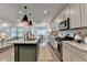 An open kitchen shows a large island with seating, granite countertops, and stainless steel appliances at 5650 Bergeson Ways, Cumming, GA 30028