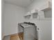 A utilitarian laundry room features a washer, dryer, and wire shelving for storage at 5650 Bergeson Ways, Cumming, GA 30028
