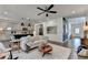 Open-concept living room with hardwood floors, stylish furnishings, and seamless flow into kitchen at 5650 Bergeson Ways, Cumming, GA 30028