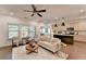 Open-concept living room and kitchen with modern lighting, neutral decor, and stainless steel appliances at 5650 Bergeson Ways, Cumming, GA 30028