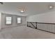 Loft area with gray carpet, natural lighting from two windows and railing at 5650 Bergeson Ways, Cumming, GA 30028