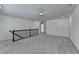 Spacious loft area with gray carpet, neutral paint, and a staircase railing at 5650 Bergeson Ways, Cumming, GA 30028