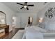 Bright main bedroom features a ceiling fan, hard wood floors, and an ensuite bathroom at 5650 Bergeson Ways, Cumming, GA 30028