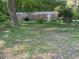 Exterior view of the house with a green yard and mature trees at 61 Kathy Ln, Temple, GA 30179
