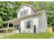 This two-story home features a cozy front porch and verdant lawn, blending charm with tranquility at 70 Gardenia Nw Dr, Atlanta, GA 30314