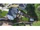 Aerial view of the home's backyard featuring a deck, gravel patio, landscaping, retaining walls, and fenced perimeter at 5420 Avonshire Ln, Cumming, GA 30040