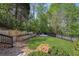 Landscaped backyard features terraced retaining walls, a lush lawn, and a gravel sitting area with firepit and Adirondack chairs at 5420 Avonshire Ln, Cumming, GA 30040