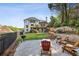 Backyard shows a gravel patio with Adirondack chairs, a grill, tiered landscaping, and a view of the home's exterior at 5420 Avonshire Ln, Cumming, GA 30040
