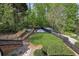 Landscaped backyard boasts a gravel seating area, a firepit, manicured lawn, and terraced retaining walls at 5420 Avonshire Ln, Cumming, GA 30040