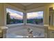 Soaking tub with views of a sunset from this lavish primary bathroom at 5420 Avonshire Ln, Cumming, GA 30040