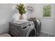 Well-lit laundry room with modern washer, dryer, floral floors, and natural light from the window at 5420 Avonshire Ln, Cumming, GA 30040