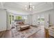 Spacious primary bedroom featuring tray ceilings, sitting area and a view of the bath at 5420 Avonshire Ln, Cumming, GA 30040