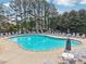 Inviting community pool with ample seating, lounge chairs, and mature trees at 3505 Chattahoochee Summit Se Ln # 25, Atlanta, GA 30339