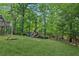 Well-manicured backyard with a play set, lush lawn, and mature trees at 6795 Preston Glen Dr, Alpharetta, GA 30005