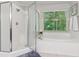 Bright bathroom with a shower, soaking tub, and natural light from the window at 6795 Preston Glen Dr, Alpharetta, GA 30005