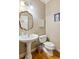 Elegant powder room featuring a pedestal sink, decorative mirror, and charming fixtures at 6795 Preston Glen Dr, Alpharetta, GA 30005
