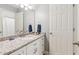 Bright bathroom featuring a granite countertop with cabinets, mirror, and a doorway visible behind the vanity at 6795 Preston Glen Dr, Alpharetta, GA 30005