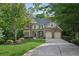 Traditional two-story home with a well-manicured lawn, mature trees, and a two-car garage at 6795 Preston Glen Dr, Alpharetta, GA 30005