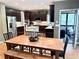 Bright kitchen with dark cabinets, stainless steel appliances, island, and open access to a dining area and screened porch at 6795 Preston Glen Dr, Alpharetta, GA 30005