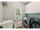 Bright laundry room with modern washer and dryer, ample cabinet space, and a convenient utility sink at 6795 Preston Glen Dr, Alpharetta, GA 30005