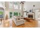 Bright and airy living room with large windows, a fireplace, and hardwood floors at 6795 Preston Glen Dr, Alpharetta, GA 30005
