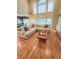Spacious living room with large windows, hardwood floors, neutral décor, and comfortable sectional seating at 6795 Preston Glen Dr, Alpharetta, GA 30005