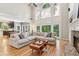 Bright living room with a stone fireplace, hardwood floors, and large windows at 6795 Preston Glen Dr, Alpharetta, GA 30005