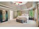 Bright main bedroom with a tray ceiling, large windows, and a cozy sitting area at 6795 Preston Glen Dr, Alpharetta, GA 30005