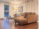 Spacious living room featuring a comfortable brown sectional sofa, glass-topped coffee table, and hardwood floors at 3629 Embry Cir, Atlanta, GA 30341