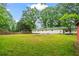 Spacious backyard featuring lush green lawn and mature trees, creating a serene outdoor oasis at 5766 Macland Rd, Powder Springs, GA 30127