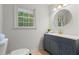 This is a bathroom with white walls, blue vanity, and a round mirror at 5766 Macland Rd, Powder Springs, GA 30127