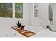 The primary bathroom has a soaking tub with built in shelves and a large window at 5766 Macland Rd, Powder Springs, GA 30127